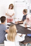 Les gens s'asseyant à la table et écoutant le haut-parleur photo libre de droits Les gens s'asseyant à la table et écoutant le haut-parleur photo libre de droits