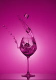 Les glaçons tombent dans un verre et l'eau est versée L'eau éclaboussant hors d'un verre de vin grand image libre de droits Les glaçons tombent dans un verre et l'eau est versée L'eau éclaboussant hors d'un verre de vin grand image libre de droits