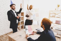 Les hommes ont collé l'autocollant sur l'ordinateur portable du collègue dans le bureau images stock Les hommes ont collé l'autocollant sur l'ordinateur portable du collègue dans le bureau images stock