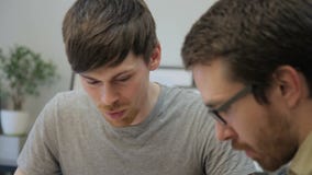 Les jeunes employés discutent le projet du bâtiment se reposant dans le bureau du bureau d'architecte banque de vidéos Les jeunes employés discutent le projet du bâtiment se reposant dans le bureau du bureau d'architecte banque de vidéos
