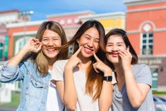 Les jeunes femmes asiatiques heureuses groupent le mode de vie de ville jouant et se causant parmi la ville en pastel de bâtiment photographie stock Les jeunes femmes asiatiques heureuses groupent le mode de vie de ville jouant et se causant parmi la ville en pastel de bâtiment photographie stock