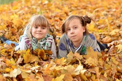 Les jeunes filles jouent dehors pendant la saison d'automne photos libres de droits Les jeunes filles jouent dehors pendant la saison d'automne photos libres de droits
