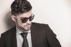 Les jeunes lunettes de soleil de port sexy d'homme d'affaires regardent loin image libre de droits Les jeunes lunettes de soleil de port sexy d'homme d'affaires regardent loin image libre de droits
