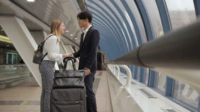 Les jeunes multi-ethniques saluent et marchent le long de la construction d'aéroport d'intérieur banque de vidéos Les jeunes multi-ethniques saluent et marchent le long de la construction d'aéroport d'intérieur banque de vidéos