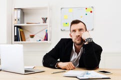 Les jeunes ont ennuyé l'homme d'affaires avec l'ordinateur portable dans le bureau blanc moderne photo libre de droits Les jeunes ont ennuyé l'homme d'affaires avec l'ordinateur portable dans le bureau blanc moderne photo libre de droits