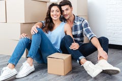 Les jeunes ont marié des couples se reposant dans leur nouvelle maison photographie stock libre de droits Les jeunes ont marié des couples se reposant dans leur nouvelle maison photographie stock libre de droits