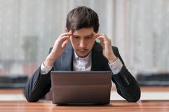 Les jeunes prévoient et homme d'affaires de pensée travaillant avec l'ordinateur portable images libres de droits Les jeunes prévoient et homme d'affaires de pensée travaillant avec l'ordinateur portable images libres de droits
