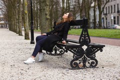 Les jeunes verres noirs reposant le ressort de sourire de femme de portrait de fille de banc de parc d'été enduisent l'automne bo photo stock Les jeunes verres noirs reposant le ressort de sourire de femme de portrait de fille de banc de parc d'été enduisent l'automne bo photo stock