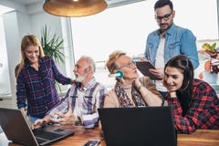 Les jeunes volontaires aident les personnes supérieures sur l'ordinateur images libres de droits Les jeunes volontaires aident les personnes supérieures sur l'ordinateur images libres de droits