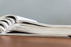 Les magazines ouvertes se trouvent sur l'un l'autre sur une table brune, documents sont en gros plan empilé photographie stock Les magazines ouvertes se trouvent sur l'un l'autre sur une table brune, documents sont en gros plan empilé photographie stock