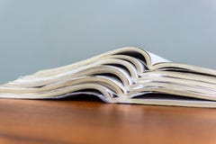 Les magazines ouvertes se trouvent sur l'un l'autre sur une table brune, documents sont en gros plan empilé photos libres de droits Les magazines ouvertes se trouvent sur l'un l'autre sur une table brune, documents sont en gros plan empilé photos libres de droits