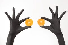 Les mains de la femme de couleur tenant des moitiés oranges Mains noires avec la mandarine savoureuse lumineuse photo libre de droits Les mains de la femme de couleur tenant des moitiés oranges Mains noires avec la mandarine savoureuse lumineuse photo libre de droits