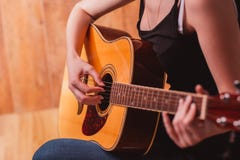 Les mains de la femme jouant la guitare acoustique, se ferment photos stock Les mains de la femme jouant la guitare acoustique, se ferment photos stock