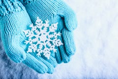 Les mains femelles dans la sarcelle d'hiver légère ont tricoté des mitaines avec le flocon de neige merveilleux de scintillement photographie stock libre de droits Les mains femelles dans la sarcelle d'hiver légère ont tricoté des mitaines avec le flocon de neige merveilleux de scintillement photographie stock libre de droits
