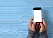 Les mains femelles tenant l'écran vide blanc de téléphone portable avec le rouge entendent images stock Les mains femelles tenant l'écran vide blanc de téléphone portable avec le rouge entendent images stock