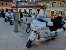 Les motos avec les lumières allumées se tiennent en conformité avec des pierres pavées dans la ville côtière de la Croatie, droit photo libre de droits Les motos avec les lumières allumées se tiennent en conformité avec des pierres pavées dans la ville côtière de la Croatie, droit photo libre de droits