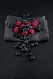 Les myrtilles, les mûres et les framboises mûres fraîches sur une serviette et une ardoise plaquent la table de cuisine Photo libre de droits Les myrtilles, les mûres et les framboises mûres fraîches sur une serviette et une ardoise plaquent la table de cuisine Photo libre de droits