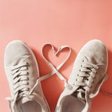 Les paires de coureurs gris avec des dentelles faisant un coeur forment Photos stock Les paires de coureurs gris avec des dentelles faisant un coeur forment Photos stock