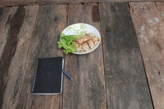 les petits pains de ressort versent la sauce dans le plat avec le carnet noir et le légume frais sur la table en bois image stock les petits pains de ressort versent la sauce dans le plat avec le carnet noir et le légume frais sur la table en bois image stock
