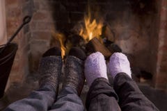 Les pieds du couple réchauffant à une cheminée photographie stock Les pieds du couple réchauffant à une cheminée photographie stock