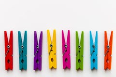 Les pinces à linge en bois colorées sur le fond blanc avec la copie espacent/concept de diversité image stock Les pinces à linge en bois colorées sur le fond blanc avec la copie espacent/concept de diversité image stock
