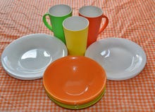 Les plats colorés sont sur la table avec une nappe lumineuse dans une cage image stock Les plats colorés sont sur la table avec une nappe lumineuse dans une cage image stock