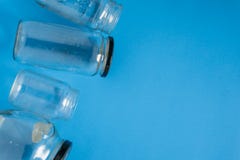 Les pots en verre d'isolement se sont étendus à plat sur le fond bleu avec la pièce pour le copyspace sur la droite photographie stock libre de droits Les pots en verre d'isolement se sont étendus à plat sur le fond bleu avec la pièce pour le copyspace sur la droite photographie stock libre de droits