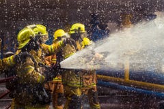 Les sapeurs-pompiers s'exerçant, premier plan est baisse de sauteur de l'eau, Sel photographie stock Les sapeurs-pompiers s'exerçant, premier plan est baisse de sauteur de l'eau, Sel photographie stock