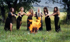 Les sorcières créent autour d'un feu de camp photographie stock libre de droits Les sorcières créent autour d'un feu de camp photographie stock libre de droits