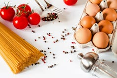 Les spaghetti se trouvent sur un fond blanc, avec des tomates-cerises, une cuillère et une fourchette photo stock Les spaghetti se trouvent sur un fond blanc, avec des tomates-cerises, une cuillère et une fourchette photo stock