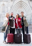 Les touristes adultes avec le bagage posent sur la rue Photographie stock libre de droits Les touristes adultes avec le bagage posent sur la rue Photographie stock libre de droits