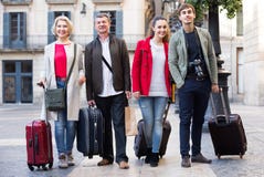 Les touristes gais avec le bagage posent dehors Photo libre de droits Les touristes gais avec le bagage posent dehors Photo libre de droits