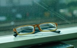Lesebrille auf Zugfenster lizenzfreie stockbilder Lesebrille auf Zugfenster lizenzfreie stockbilder