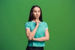 Let me think. Doubtful pensive woman with thoughtful expression making choice against grreen background Stock Images Let me think. Doubtful pensive woman with thoughtful expression making choice against grreen background Stock Images