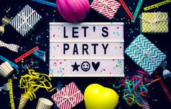 Let`s party and celebrate concepts with text on cinema light box and colorful element prop on dark with copy space background