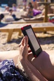 Lettore elettronico, leggente sulla spiaggia immagini stock libere da diritti Lettore elettronico, leggente sulla spiaggia immagini stock libere da diritti