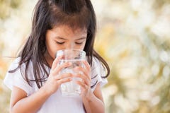 Leuk Aziatisch meisje die zoet water van glas drinken royalty-vrije stock afbeeldingen Leuk Aziatisch meisje die zoet water van glas drinken royalty-vrije stock afbeeldingen