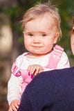 Leuk babymeisje die uit van de rug van de moeder kijken royalty-vrije stock foto Leuk babymeisje die uit van de rug van de moeder kijken royalty-vrije stock foto