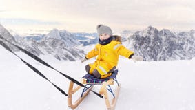 Leuk Kaukasisch weinig jongen die in de bergen van Alpen sledding stock afbeelding Leuk Kaukasisch weinig jongen die in de bergen van Alpen sledding stock afbeelding