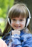 Leuk meisje die aan muziek luisteren en van het park genieten stock foto's Leuk meisje die aan muziek luisteren en van het park genieten stock foto's