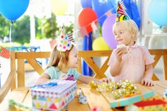 Leuk vieren weinig jongen en meisje die pret hebben en verjaardagspartij met kleurrijke decoratie en cake Royalty-vrije Stock Fotografie Leuk vieren weinig jongen en meisje die pret hebben en verjaardagspartij met kleurrijke decoratie en cake Royalty-vrije Stock Fotografie