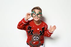 Leuk weinig jongen in Kerstmissweater met partijglazen stock afbeeldingen Leuk weinig jongen in Kerstmissweater met partijglazen stock afbeeldingen