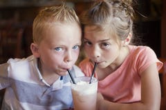 Leuke jonge geitjes die een drank van de munt Italiaanse soda delen bij een koffie stock fotografie Leuke jonge geitjes die een drank van de munt Italiaanse soda delen bij een koffie stock fotografie