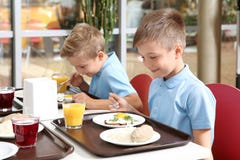 Leuke kinderen bij lijst met gezond voedsel in school stock fotografie Leuke kinderen bij lijst met gezond voedsel in school stock fotografie