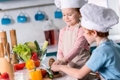leuke kleine jonge geitjes in chef-kokhoeden die plantaardige salade samen voorbereiden royalty-vrije stock foto's leuke kleine jonge geitjes in chef-kokhoeden die plantaardige salade samen voorbereiden royalty-vrije stock foto's