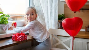 Leuke kleutermeisje het vieren 6de verjaardag Meisje die met brutale glimlach haar verjaardag cupcake in de keuken eten stock afbeelding Leuke kleutermeisje het vieren 6de verjaardag Meisje die met brutale glimlach haar verjaardag cupcake in de keuken eten stock afbeelding