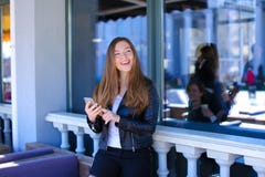 Leuke vrouwelijke persoon die door smartphone bij straatkoffie babbelen Royalty-vrije Stock Foto Leuke vrouwelijke persoon die door smartphone bij straatkoffie babbelen Royalty-vrije Stock Foto