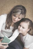 Leute, Familie und Technologiekonzept - glückliches Mädchen und Mutter mit Smartphone zu Hause lizenzfreie stockfotos Leute, Familie und Technologiekonzept - glückliches Mädchen und Mutter mit Smartphone zu Hause lizenzfreie stockfotos