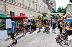 Leute gehen und besuchen Künstler an der Straßen-Lieferung Lizenzfreies Stockbild Leute gehen und besuchen Künstler an der Straßen-Lieferung Lizenzfreies Stockbild
