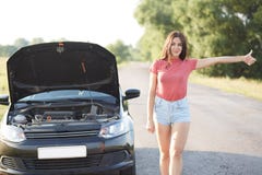 Leute und Probleme mit Transport Attraktiver unexperienced weiblicher Fahrer macht Endgeste auf Straße, steht brocken nahe Auto, stockfotografie Leute und Probleme mit Transport Attraktiver unexperienced weiblicher Fahrer macht Endgeste auf Straße, steht brocken nahe Auto, stockfotografie